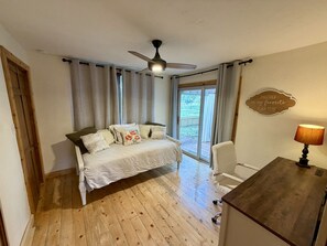 A bedroom with a bed, a desk, a chair, a ceiling fan, and a window with curtains. - Peaceful Farmhouse - Hot Tub - Office (Silt)