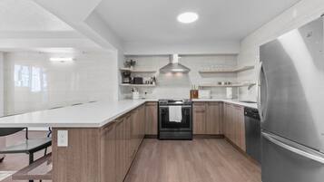 A modern kitchen with a central island, stainless steel appliances, and wooden cabinetry.