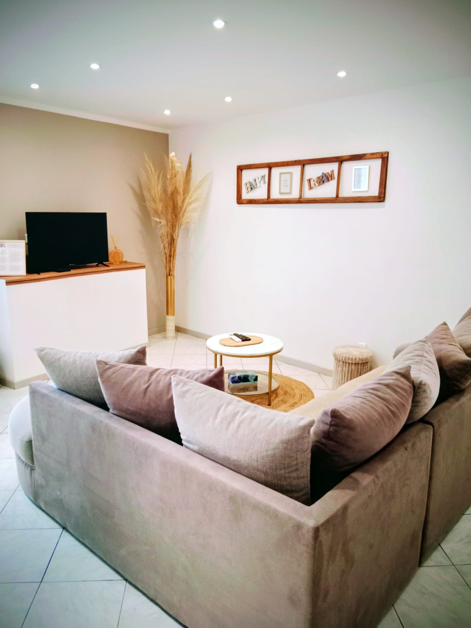 A living room with a sofa, a coffee table, and a TV on a stand.