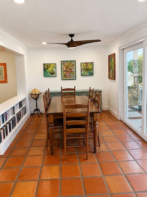 A dining area with a table and chairs, a ceiling fan, and artwork on the walls. - Direct Oceanfront Retreat with Ocean-to-River Views  Sleeps 8 (Cocoa Beach)