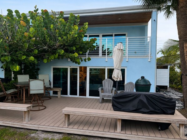 A modern house with a deck, outdoor seating, and a covered grill area. - Direct Oceanfront Retreat with Ocean-to-River Views  Sleeps 8 (Cocoa Beach)