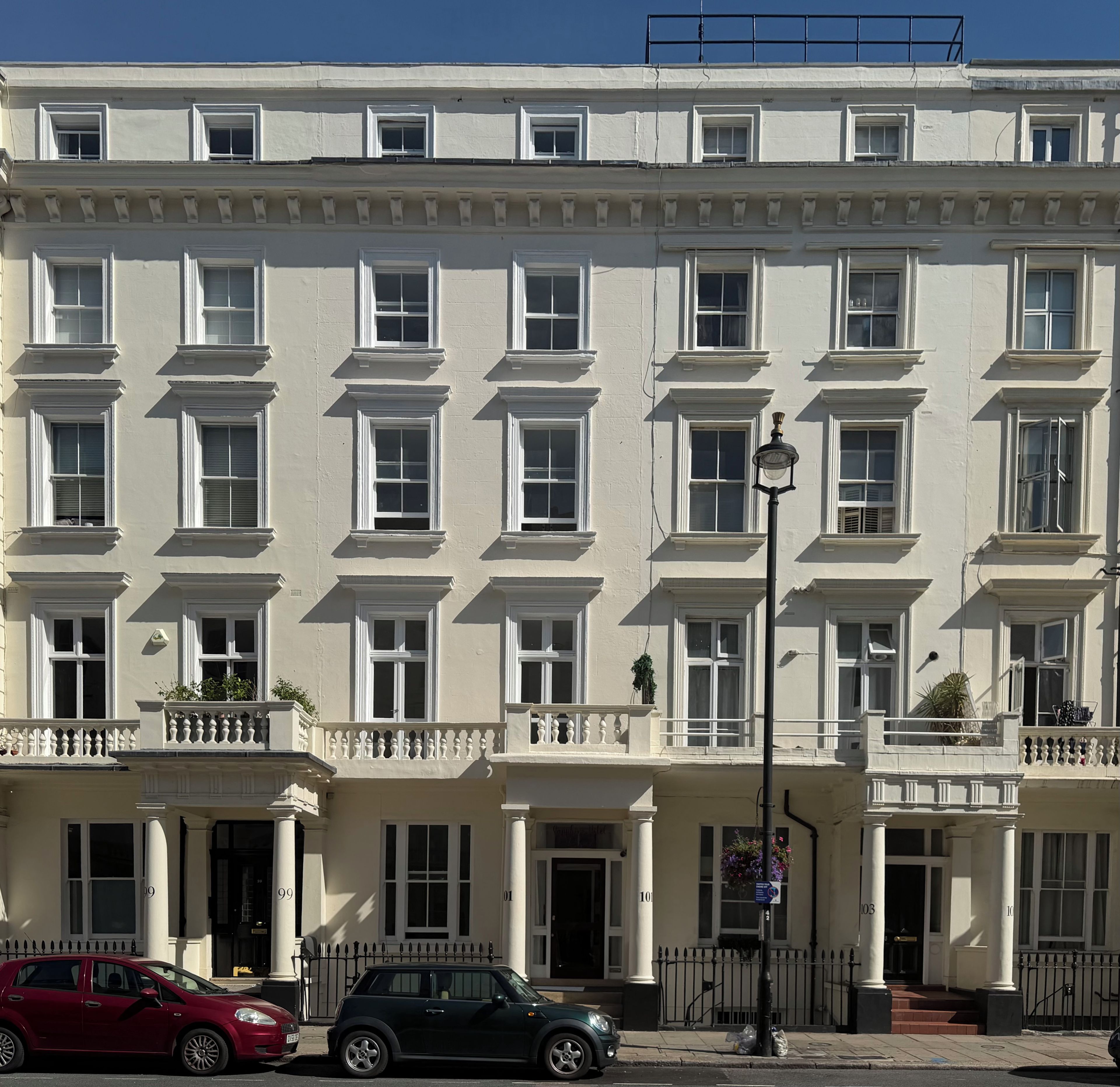 A multi-story building with a symmetrical facade, evenly spaced windows, and a central entrance with steps.