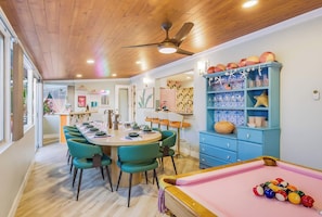 A dining area with a pool table, teal chairs, and a ceiling fan. - Good Vibes & Poolside Nights | San Diego (San Diego)