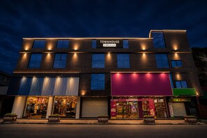 A multi-story building with a storefront labeled 'TOUMHOUSE' and 'OYO-Serviced'. - Deluxe Apsara Tourist Homes (Adoor)