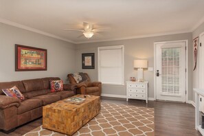 A living room with a brown leather sofa, a wooden coffee table, a white side table with a lamp, and a door with a window. -
Walking distance to Miss State campus , very close to downtown Starkville . (Starkville)