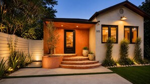 A modern house with a number 101 sign, a front porch with steps, and a well-maintained garden. - Vrbo Property (Miami)