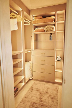 Ein begehbarer Kleiderschrank mit zahlreichen Regalen, Schubladen und Platz zum Aufhängen.