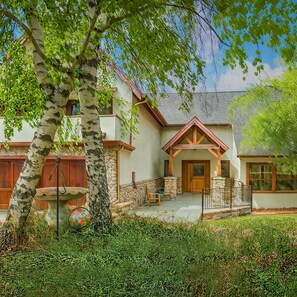 A two-story house with a stone foundation, wooden beams, and a front porch. - Spacious Tavern Bay Retreat  4BR Luxury Home (Lake Arrowhead)