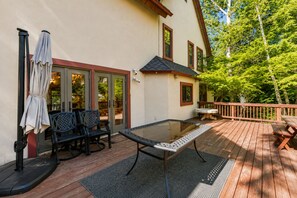 Eine Terrasse im Freien mit Tisch, Stühlen und einer Bank, alle mit Glasplatten.