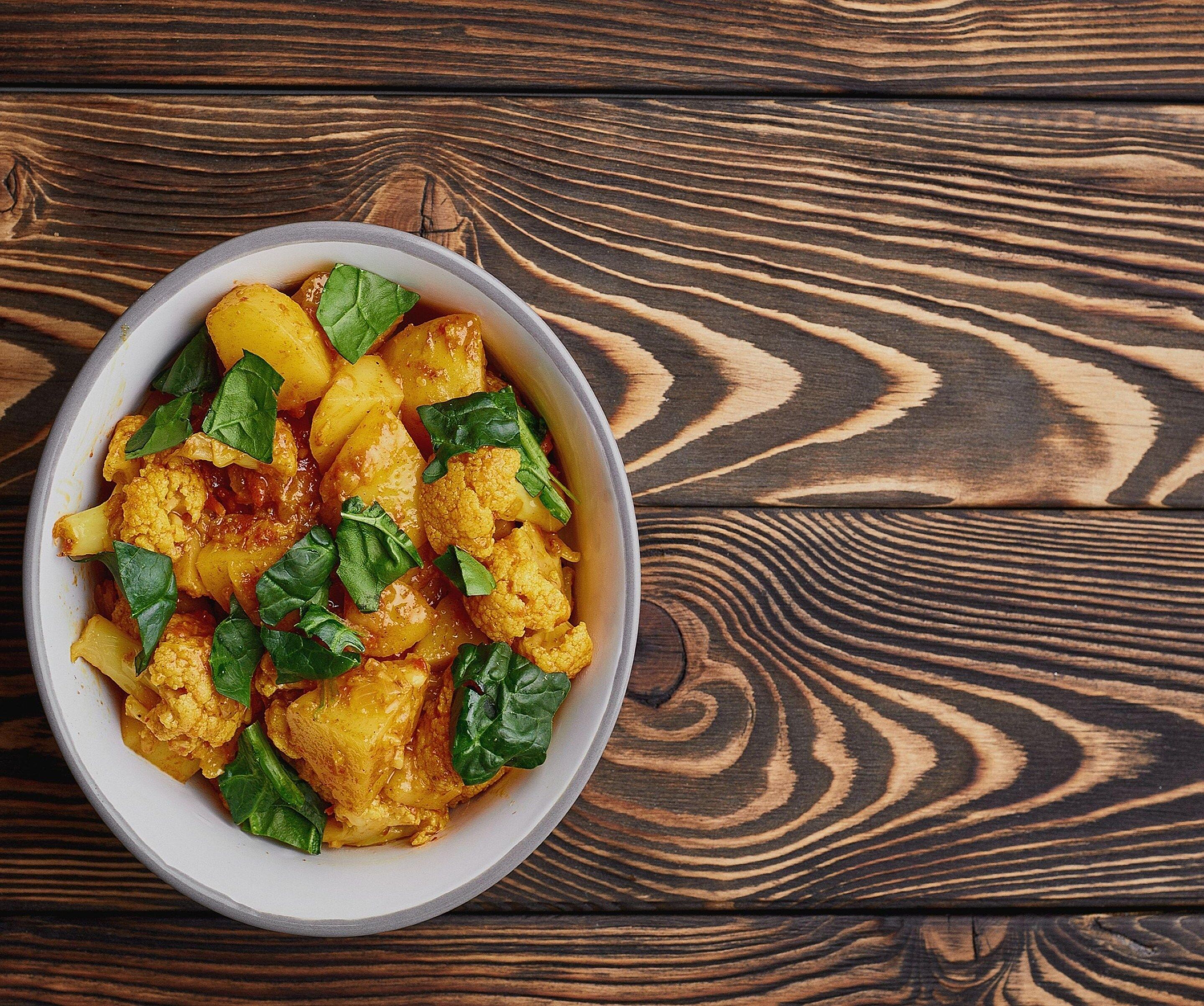 A bowl of food on a wooden table.