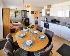 A modern kitchen with white cabinets, a built-in oven, and a coffee maker. - Winterberg City & Ski (Winterberg)