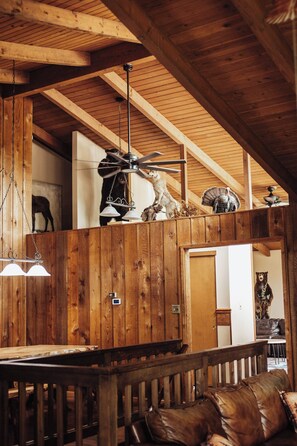 A rustic interior with wooden beams, a ceiling fan, and a bench. - Rustic country getaway with private lake! - Great for large groups and families (Newark)