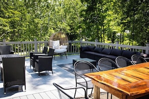 Um terraço com mobiliário externo, incluindo um sofá, cadeiras e uma mesa.