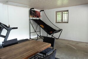 A room with a basketball hoop, a dining table, and chairs. - Rustic country getaway with private lake! - Great for large groups and families (Newark)