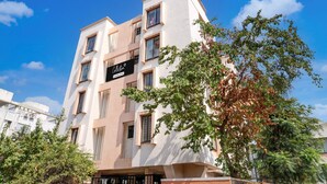 A multi-story building with a sign indicating it is a collection and company-serviced property. - Deluxe Zudio 7 Baner (Pune)