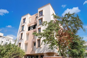A multi-story building with a sign indicating it is a collection and company-serviced property. - Deluxe Zudio 7 Baner (Pune)