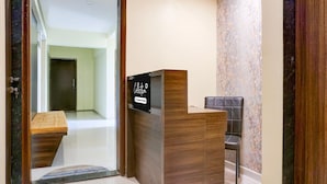 A reception desk with a sign indicating it's a company-serviced collection point. - Deluxe Zudio 7 Baner (Pune)