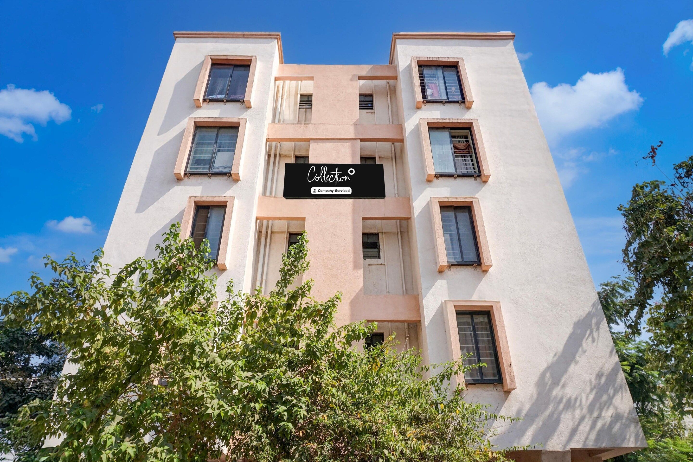 A multi-story building with a sign indicating it is a company-serviced collection.