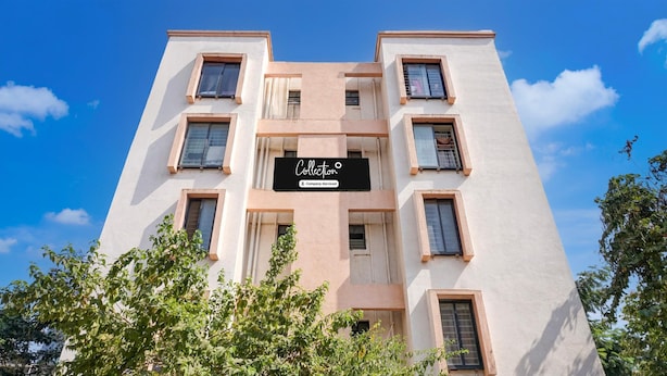 A multi-story building with a sign indicating it is a company-serviced collection. - Deluxe Zudio 7 Baner (Pune)