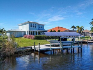 Ein Anwesen am Wasser mit Steg, einem Haus und einem Boot.