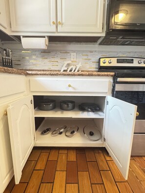 A kitchen with white cabinets, a countertop, and a stove. - The Luxe Haven - 3BR • Huge Gated Yard • Private Patio (Mobile)