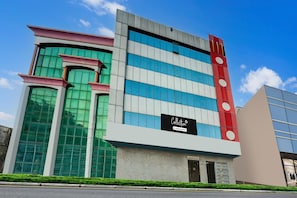 A modern building with a distinctive facade featuring a mix of geometric shapes and a prominent vertical element with circular patterns. - Super Collection O Sindhi Camp (Jaipur)