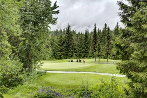 A golf course surrounded by dense forest. - Alpine Greens 5 Star renovated townhouse (Whistler)