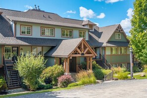 A two-story house with a covered porch and a staircase leading to the entrance. - Tremblant Prestige - Les Falaises 138-2 (Mont-Tremblant)