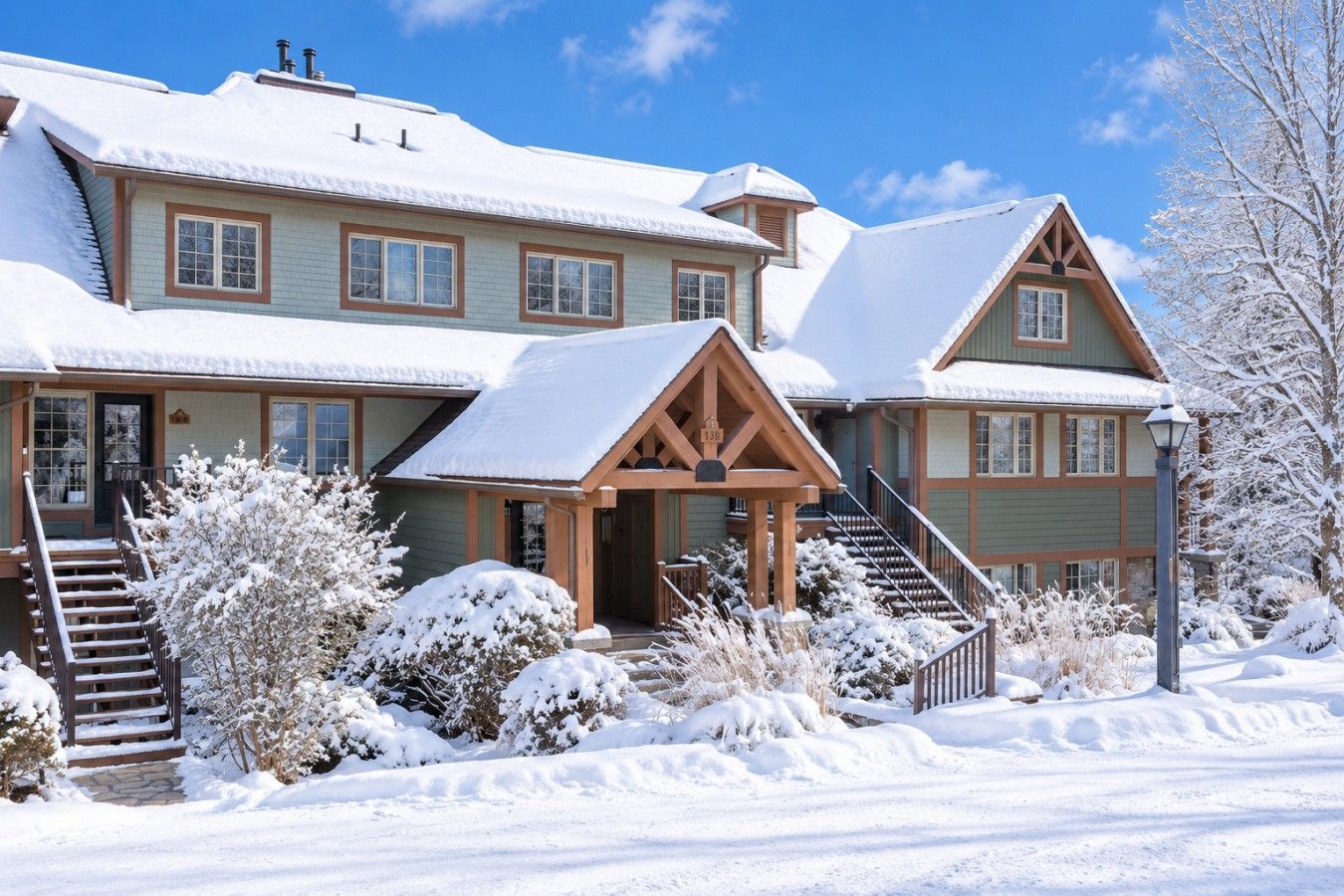 A two-story lodge with a covered front porch and a staircase leading to the entrance.
