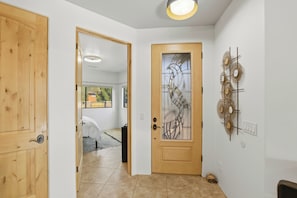 Ein Flur mit einer Holztür, einer Tür mit Milchglas und einem Wandbild.