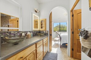 Una cuina moderna amb una illa gran, armaris de fusta i vista cap a l'exterior.
