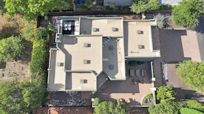 Vue aérienne d’une propriété dotée d’un patio, d’un espace salon extérieur et d’un jardin clôturé.