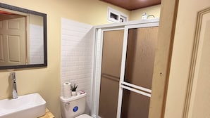A bathroom with a white toilet, a sink, and a shower enclosure. - Hotel y Centro Turístico Valle Encantado (Gracias)