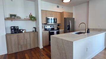 Une cuisine moderne avec des meubles en bois, des appareils en acier inoxydable et un îlot central.