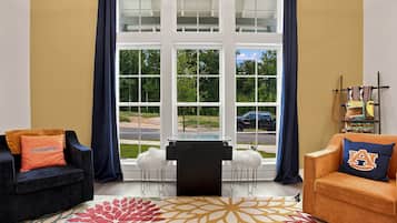 Ein Wohnzimmer mit großem Fenster, zwei Sofas, einem Couchtisch und einem gemusterten Teppich.