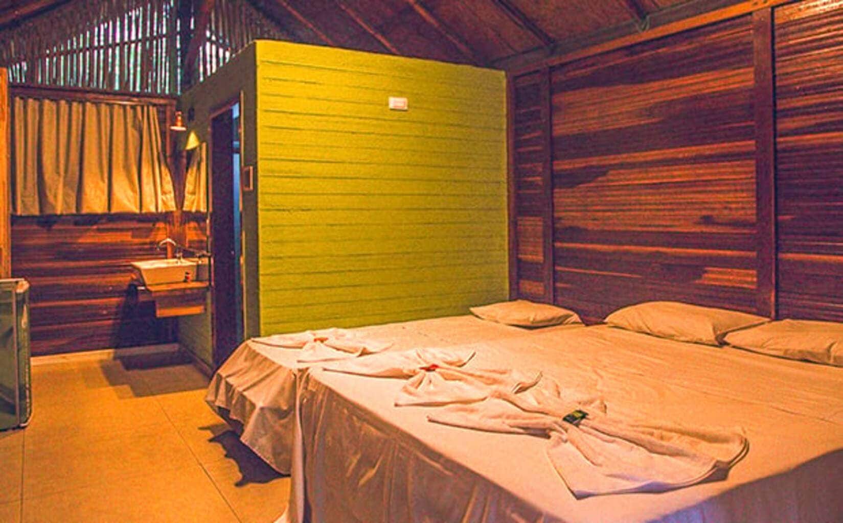 A room with a bed, a small table, and a green wall.
