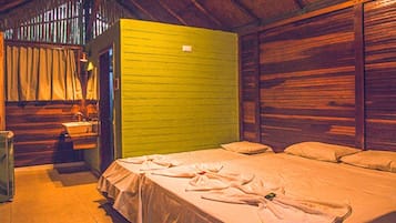 A room with a bed, a small table, and a green wall.