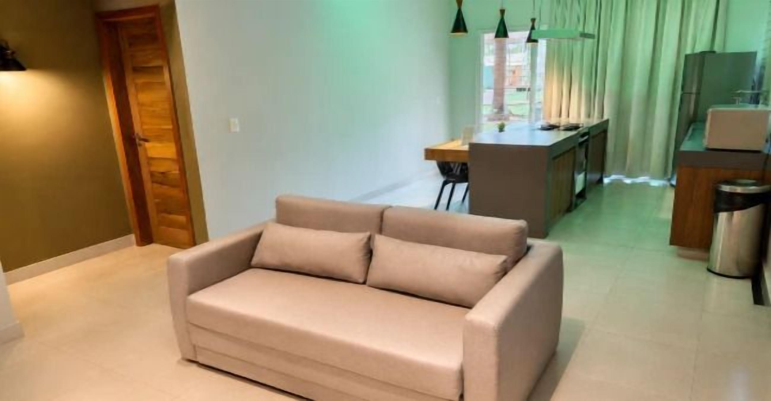 Una sala de estar con sofá, comedor y kitchenette.