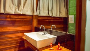 A bathroom with a wooden vanity, a white sink, and a mirror. - Eco Park Chapada Indaiá (Formosa)