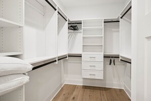 A walk-in closet with white shelving, drawers, and hanging rods. - Paris Mountain Escape (Greenville County)