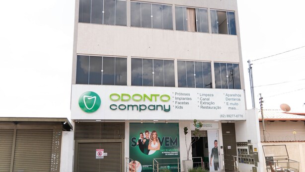 A multi-story building with a sign for 'ODONTO company' featuring dental services. - CONDOMÍNIO SONHARE - 103 (ANAPOLIS)