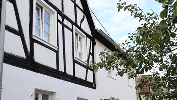 Ein traditionelles Fachwerkhäuschen mit weißen Wänden und dunklen Holzbalken.