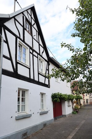 Ein traditionelles Fachwerkhäuschen mit weißen Wänden und dunklen Holzbalken.