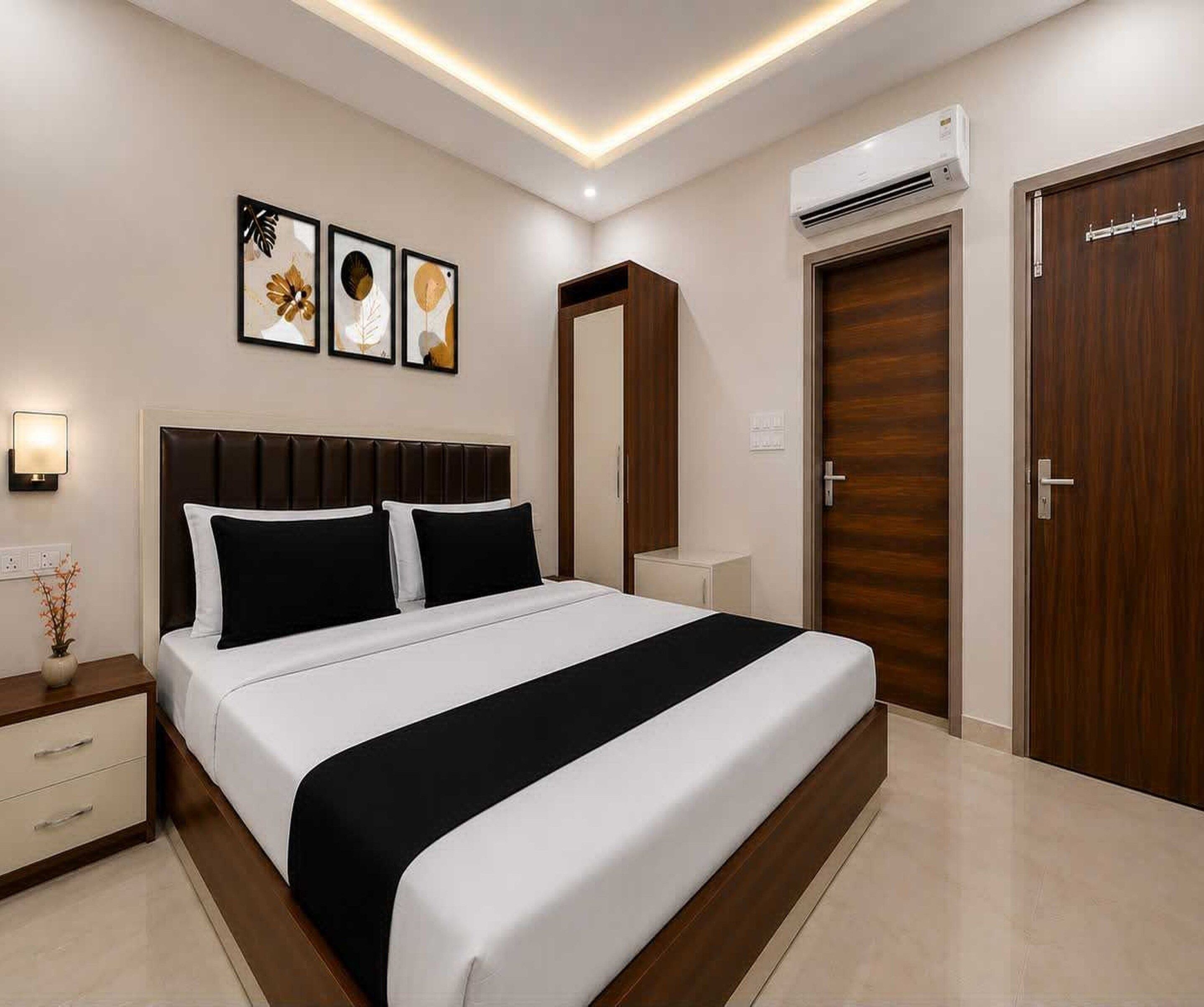 A modern bedroom with a bed, bedside table, wall-mounted artwork, an air conditioning unit, and a wooden door.