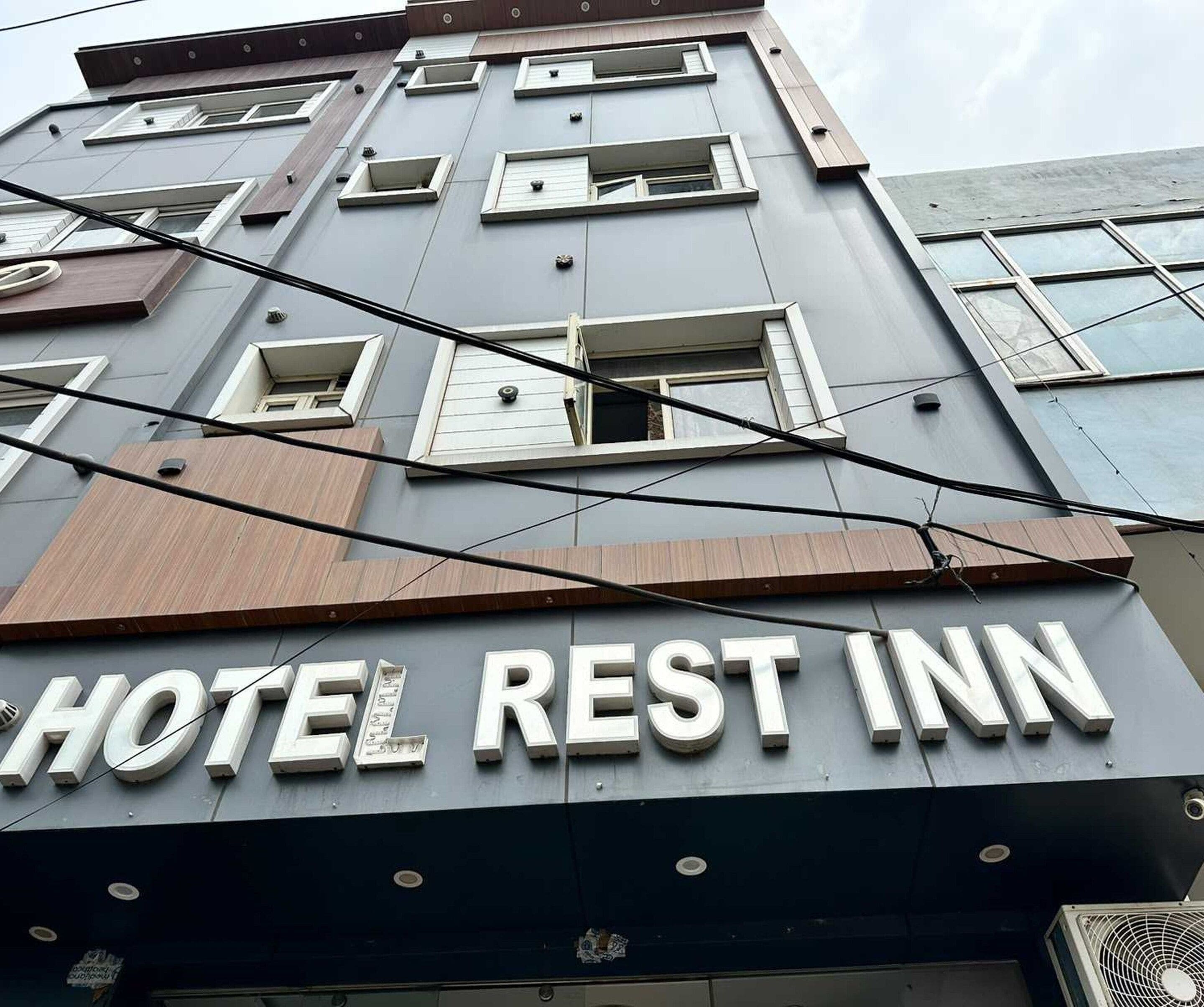 A hotel with a sign reading 'HOTEL REST INN' and multiple windows.