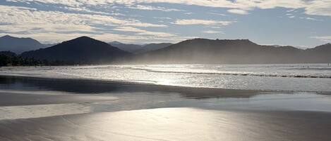 A beach with a clear sky and sun shining.