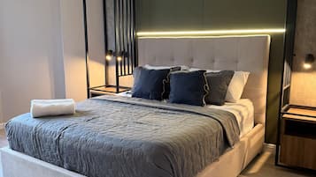 A modern bedroom with a large bed, a headboard with integrated lighting, and a minimalist design.