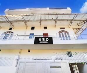 A hotel building with a sign indicating it is company-serviced. - Saver Double Hotel White Retreat Inn (Vikasnagar)