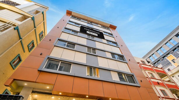 A multi-story hotel with a modern design, featuring a prominent sign indicating it is a serviced property. - Townhouse Mindspace Road Gachibowli (Hyderabad)