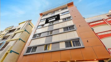A multi-story building with a sign indicating it is serviced by OYO.